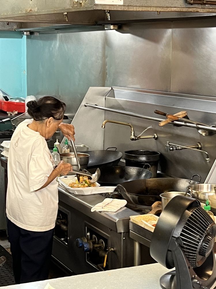 The owner cooking fresh at the wok inside Thai Express